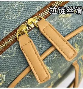 Detailed macro view of the smooth metal zipper and blue denim texture on the cute bear backpack