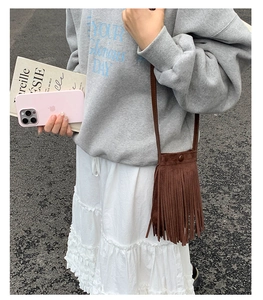 Détail d'un sac bandoulière en daim marron avec des franges élégantes pour un look rétro