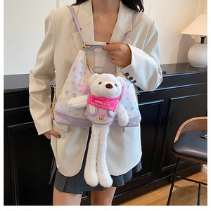 Detail of cartoon shoulder bag with large plush bear pendant and metal chain strap