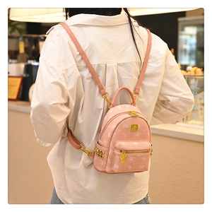 Close-up of pink bear pattern leather backpack with gold rivet details and adjustable straps