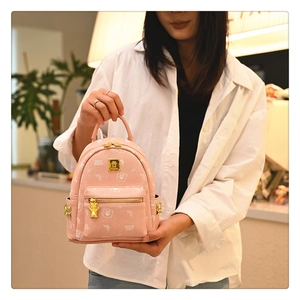 Close-up of pink mini backpack with bear prints and golden bear-shaped zippers