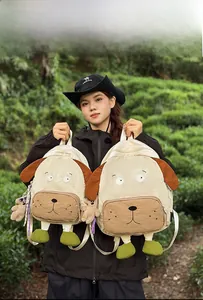 Comparison of large and small cartoon dog backpacks in cream and brown outdoors