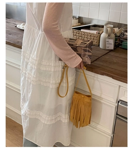 Détail d'un sac à bandoulière jaune à franges longues et au design de style bohème