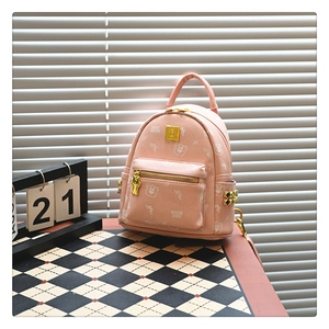 Close-up of pink backpack with cartoon bear print, metal studs and zipper detail