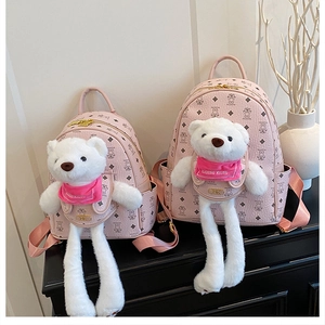 Dettaglio di zaini rosa in due dimensioni con orsetti di peluche e motivi stampati