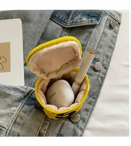 Internal view showing capacity of the round yellow fabric coin purse for wireless earbuds