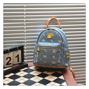 Detail of denim blue mini backpack with bear print and gold stud side ornaments