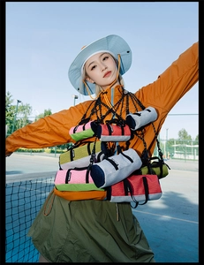 Outdoor view of a lightweight mini cylinder crossbody bag with adjustable strap and mesh detail