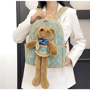 Detail of light green canvas backpack with bear plush charm and vintage pattern print