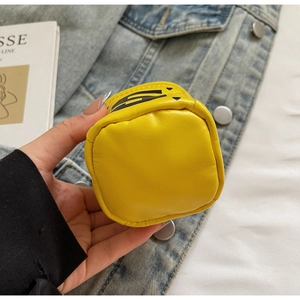 Close-up of a bright yellow mini round leather coin purse with heart print and zipper