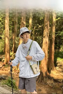 Outdoor leisure crossbody bag in beige and green, modeled during a forest hike