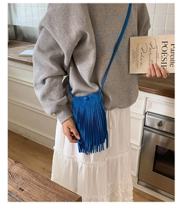 Détail d'un sac bandoulière bleu vif à franges longues avec sa fine bandoulière assortie