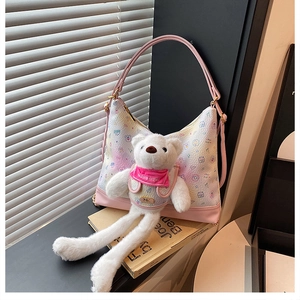 Close-up of pink gradient faux leather bag with bear plush and cute cartoon print