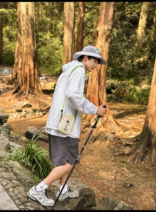 Close-up of lightweight hiking crossbody bag with green drawstring on outdoor sportswear