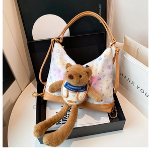 Detail of cute teddy bear shoulder bag with colorful cartoon prints in a luxury gift box