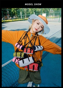 Mini cylindrical running crossbody bag in multi-color nylon shown on a blue court
