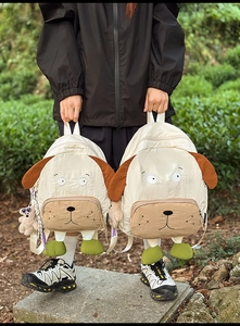 Detail of two dog-themed backpacks with plush textures and 3D decorative feet