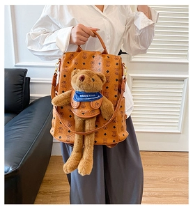 Detail eines braunen Mode-Rucksacks mit Teddybären-Ornament und Rauten-Print-Muster