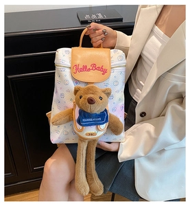 Close-up of white cartoon backpack with Hello Baby embroidery and plush bear charm
