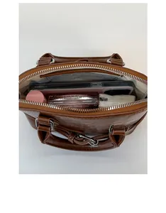 Interior view of brown shell bag showing capacity for phone and cosmetics