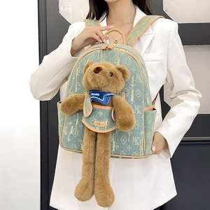 Pale green canvas backpack with floral monogram and cute plush bear accessory