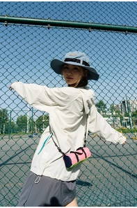 Pink and lime green nylon barrel bag shown with casual outdoor sportswear and hat