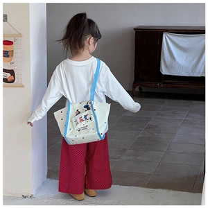 Vue détaillée d'un enfant portant un sac fourre-tout en toile à motif de chiot