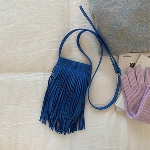 Détail d'un sac à bandoulière bleu roi à franges avec texture mate et lanière en cuir