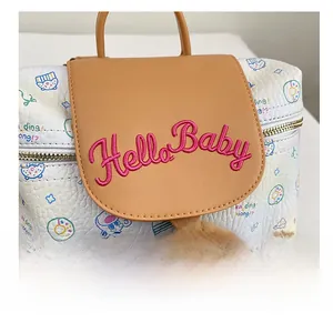 Detail showing white leather bag with cartoon cat print and Hello Baby embroidery