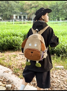 Outdoor shot of a cute 3D dog-shaped cartoon backpack with a bear pendant detail