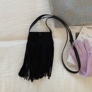 Détail du sac à bandoulière en similicuir mat noir orné de longues franges tendance