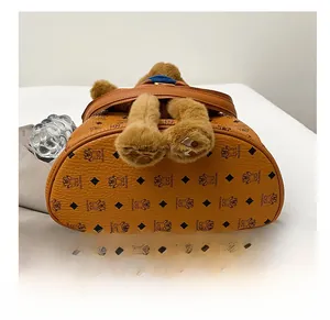 Nahaufnahme des strapazierfähigen Lederrucksack-Bodens mit Bären-Monogramm und Plüschtier