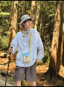 Outdoor sport detail of beige and blue drawstring crossbody bag with hiking pole in forest