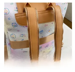 Close-up of wide leather shoulder straps and cute cartoon bear prints on a cream backpack