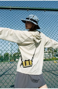 Outdoor lifestyle view of a vibrant color-block mini crossbody bag for active travel