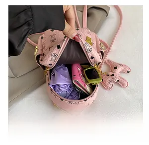 Vista interna del mini zaino rosa che mostra la capacità per ombrello, portafoglio e occhiali