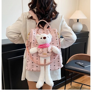 Nahaufnahme des rosa Rucksacks mit geometrischen Mustern und weißem Bären-Anhänger