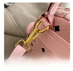 Dettaglio borsa rosa in finta pelle con gancio rotante in metallo dorato e stampa orso