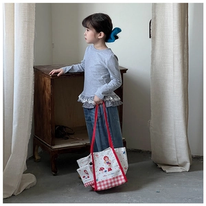 Détail du sac cabas enfant en toile avec motif champignon et anses à carreaux rouges
