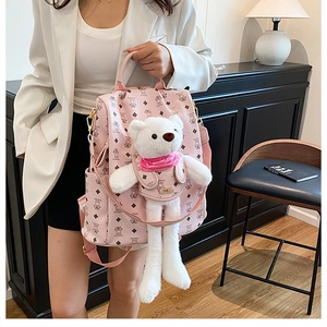 Nahaufnahme des rosa Mini-Rucksacks mit Bärenpuppen-Anhänger und Rautenmuster-Textur