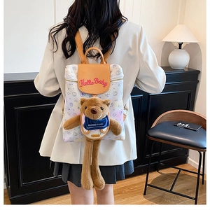 Detail view of cartoon bear backpack with Hello Baby embroidery and brown leather lid