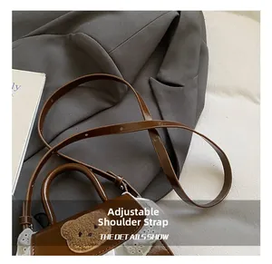 Detail of adjustable leather strap and lace trim on a mini brown bear crossbody bag