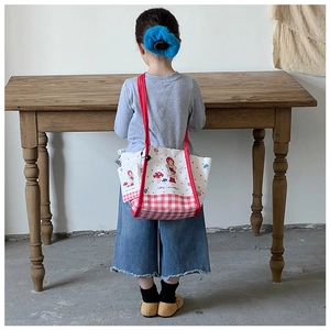 Détail du sac cabas pour enfant en toile avec motifs champignons et carreaux rouges