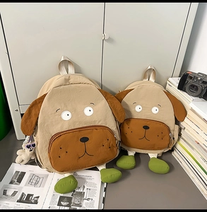Detailed view of dog-shaped backpacks in two sizes with bear charm and camera props