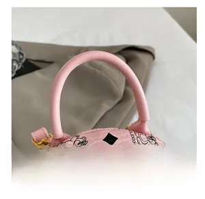 Dettaglio del manico in pelle rosa dello zaino con stampa di orsetti e zip in metallo