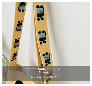 Detail of bright yellow canvas shoulder strap with cute cartoon elephant prints