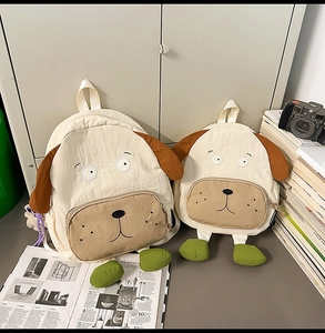 Detail of two dog-shaped canvas backpacks in different sizes with cute ear embroidery
