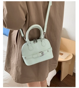 Detail of mint green shell crossbody bag featuring smooth PU leather and a chic buckle strap
