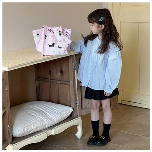 Détail du sac en toile à carreaux roses avec chiens de dessin animé et arcs-en-ciel