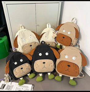 Detail view of multi-color cartoon dog backpacks featuring embroidery and 3D ears